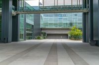 a building has glass and steel on the exterior and walkways as well as plants