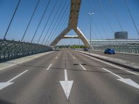 a truck driving across a bridge near a street corner near buildings and a bridge with many cables