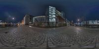 a street scene with fish eye lens images of buildings and city lights at night time