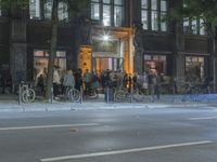 people are gathered in the dark to watch a biker in a bike lane at night