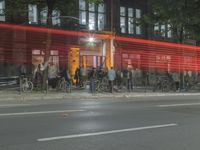 people are gathered in the dark to watch a biker in a bike lane at night