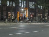 people are gathered in the dark to watch a biker in a bike lane at night