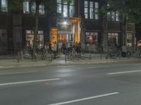 people are gathered in the dark to watch a biker in a bike lane at night