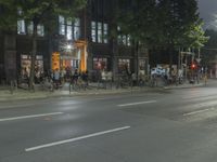 people are gathered in the dark to watch a biker in a bike lane at night