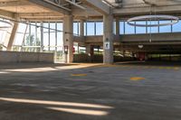 the concrete floor of a parking lot with two buildings and large windows on one side and some bright yellow striped line