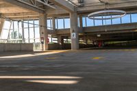 the concrete floor of a parking lot with two buildings and large windows on one side and some bright yellow striped line