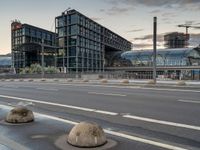 several rocks are sitting by the road on the pavement in front of a tall building