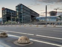 several rocks are sitting by the road on the pavement in front of a tall building