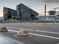 several rocks are sitting by the road on the pavement in front of a tall building