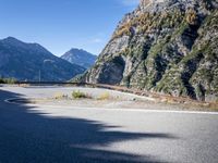 mountains and road side with no traffic on it in europes alps wilderness area with a winding curve