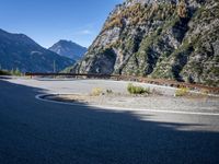 mountains and road side with no traffic on it in europes alps wilderness area with a winding curve