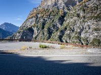mountains and road side with no traffic on it in europes alps wilderness area with a winding curve