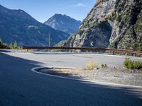 mountains and road side with no traffic on it in europes alps wilderness area with a winding curve