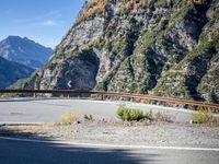 mountains and road side with no traffic on it in europes alps wilderness area with a winding curve
