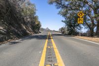 the yellow warning sign indicates drivers to stop in the road in the distance from the car