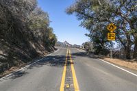 the yellow warning sign indicates drivers to stop in the road in the distance from the car