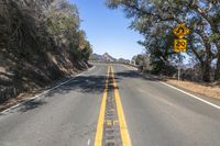 the yellow warning sign indicates drivers to stop in the road in the distance from the car