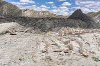 some rocks that are on the ground in the mountains and under a sky with clouds