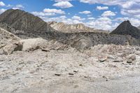 some rocks that are on the ground in the mountains and under a sky with clouds