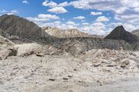 some rocks that are on the ground in the mountains and under a sky with clouds