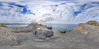 this fish eye photo shows the view from the rocks of the ocean through which you can see a beach