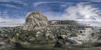 an artistic view of rocky landscape with seaweed in foreground and rocks in the background