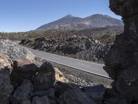 a car is shown seen near a rocky, rocky mountain road with mountains in the background