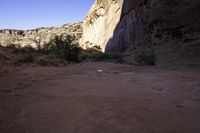 view down an open rocky riverbed near cliffs, with a frisbee on the ground