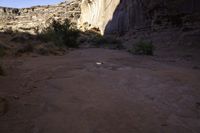 view down an open rocky riverbed near cliffs, with a frisbee on the ground