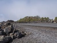 the rocky road stretches off from a crater with large rocks on either side of it