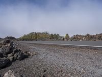 the rocky road stretches off from a crater with large rocks on either side of it