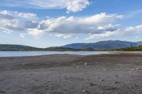 rocky shore and mountain range on the coast of a body of water with rocks in it