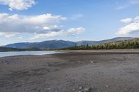 rocky shore and mountain range on the coast of a body of water with rocks in it
