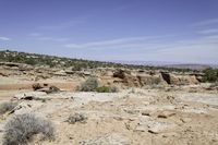 the view from above an area that contains rocky terrain and mountains with sparse shrubs, shrubs and rocks