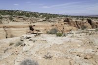 the view from above an area that contains rocky terrain and mountains with sparse shrubs, shrubs and rocks