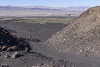 an aerial view of rocky terrain with mountains and plains in the distance, in a vast area