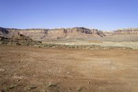 rocky terrain with sparse grass and rocks in the foreground on a clear day in the desert