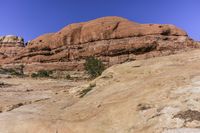 an open rocky area with rocks and trees on it and a mountain in the background