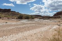 a very long rocky trail through some desert hills and canyons, and there is water in the river flowing from one point at the bottom to the other