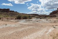 a very long rocky trail through some desert hills and canyons, and there is water in the river flowing from one point at the bottom to the other