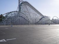 a roller coaster coaster on a track next to an empty parking lot in an amusement area