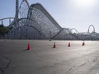 a roller coaster coaster on a track next to an empty parking lot in an amusement area