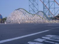 roller coaster and empty lot at sunset in amusement park area - - image by ©wied images / corbra