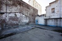 a large empty room in an old building next to two buildings with a brick wall