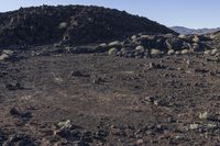 a pile of rocks in the middle of a barren area with many small rocks around