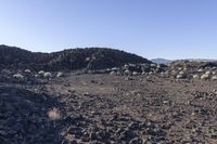 a pile of rocks in the middle of a barren area with many small rocks around