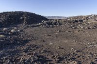 a pile of rocks in the middle of a barren area with many small rocks around