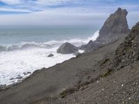 the waves hit rocks near the shore of the water's edge and crash on it