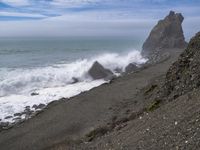 the waves hit rocks near the shore of the water's edge and crash on it