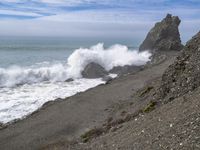 the waves hit rocks near the shore of the water's edge and crash on it